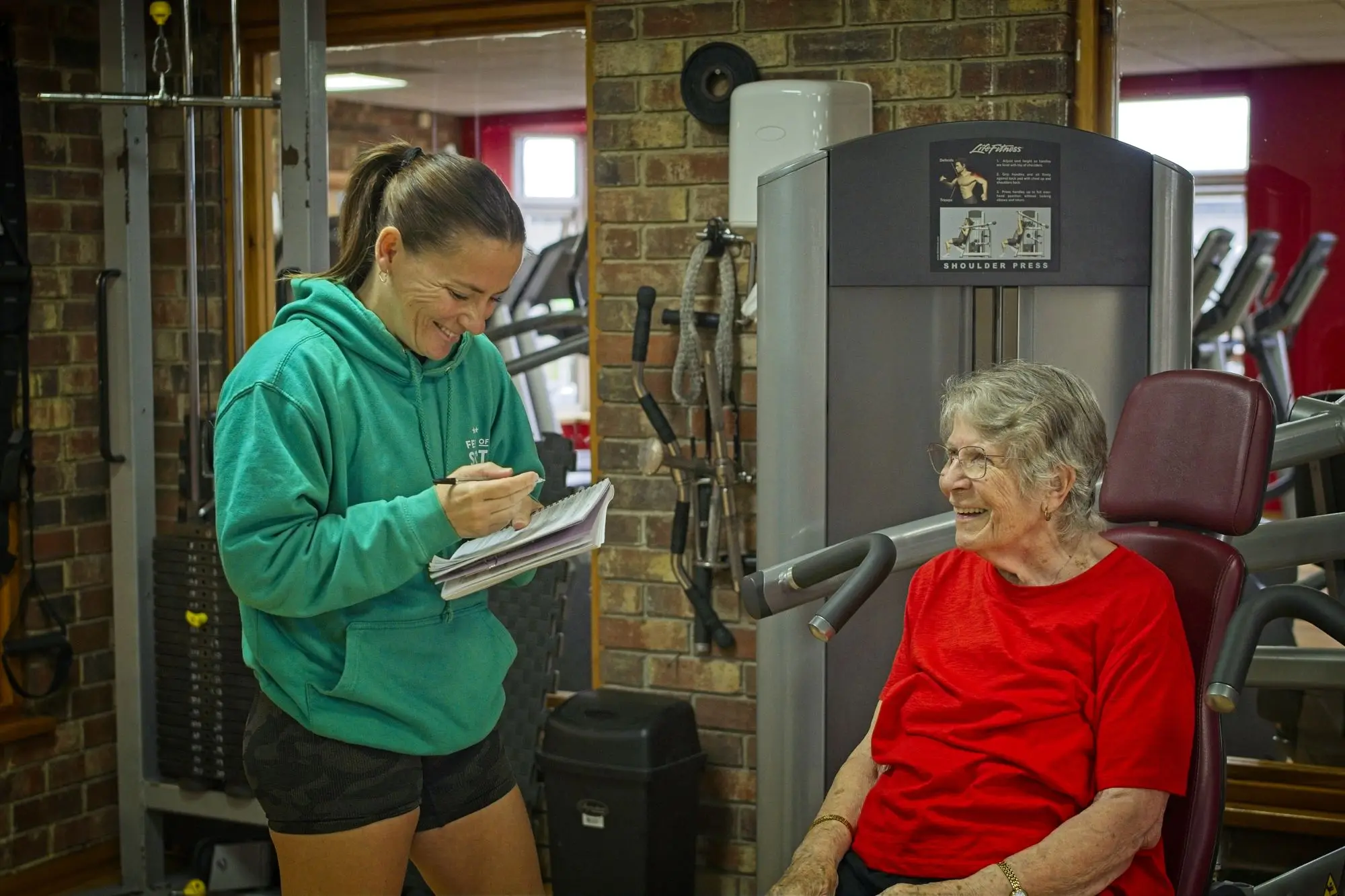 Becky taking Liz through her programme on a resistance machine