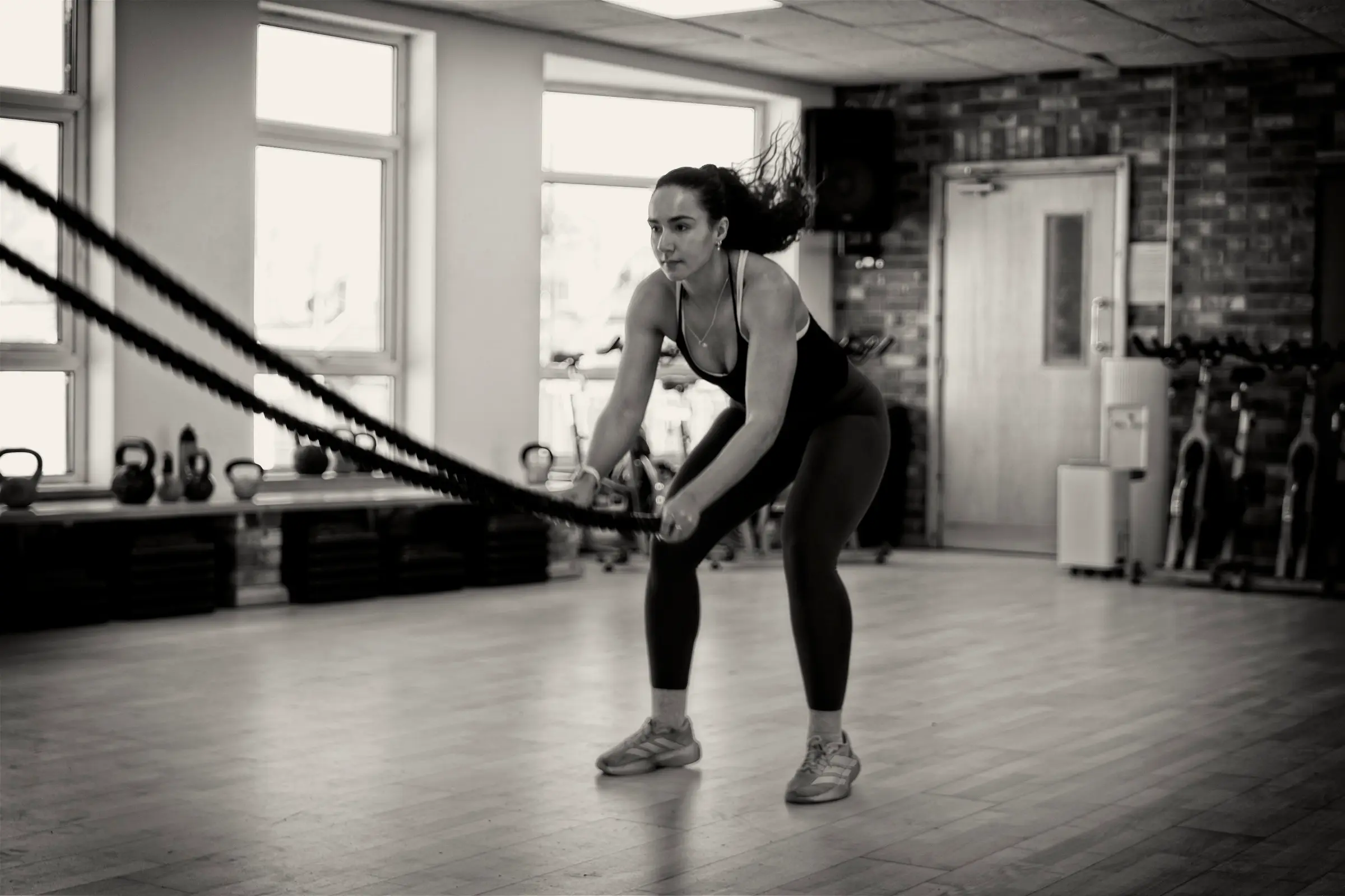 A member working the battle ropes in the studio