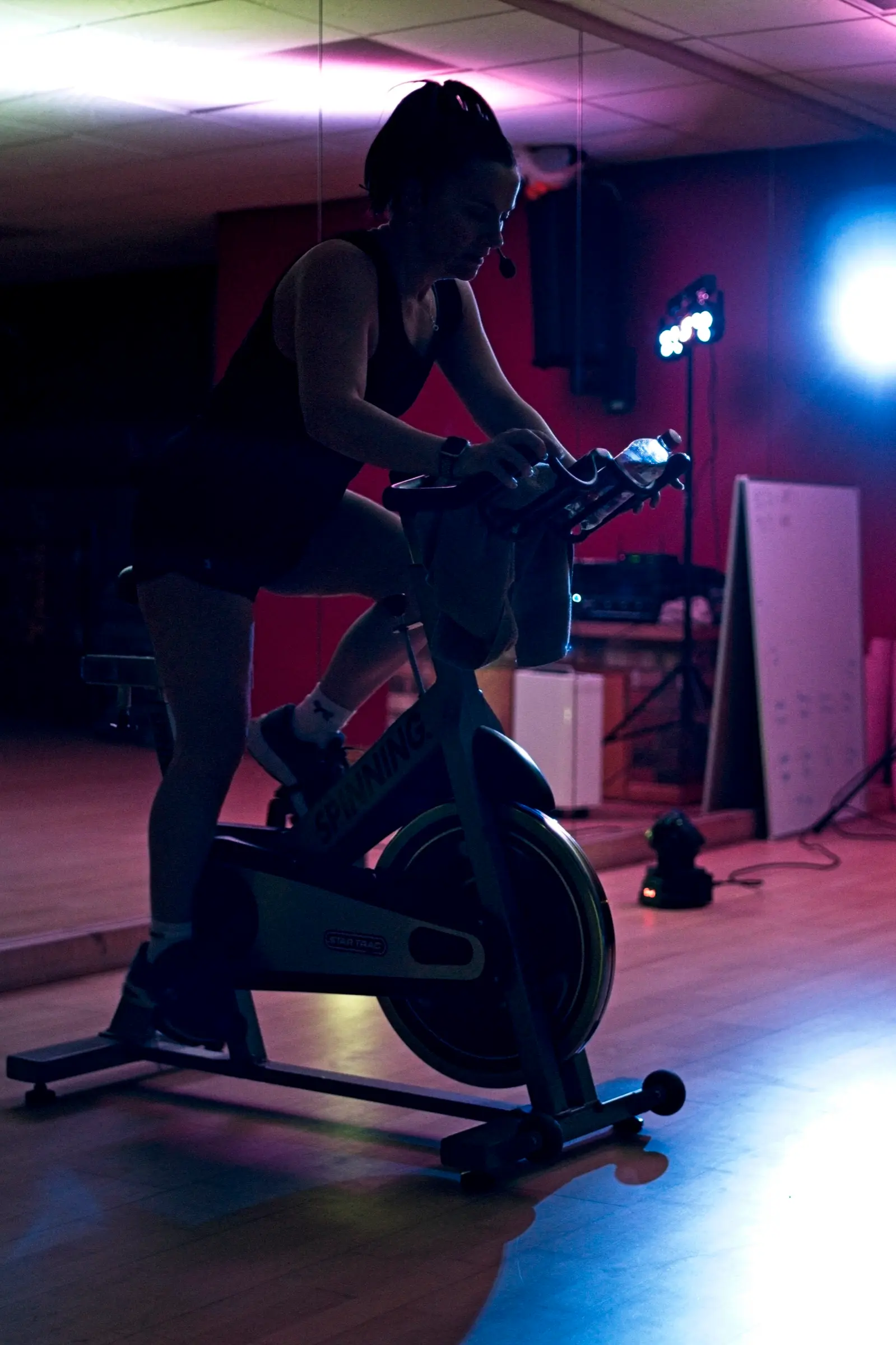 Spin Cycling class under coloured studio lights